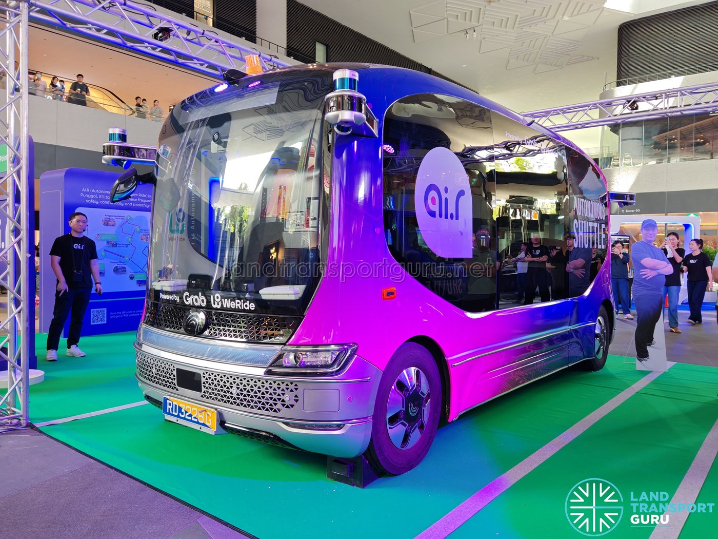 A WeRide autonomous shuttle with Grab branding on a Singapore street.