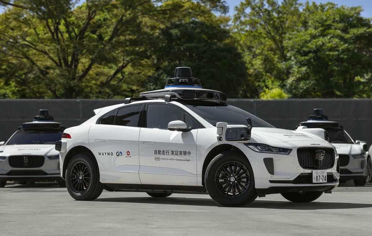 A Waymo Jaguar I-PACE autonomous taxi on a Tokyo street during public-road testing.